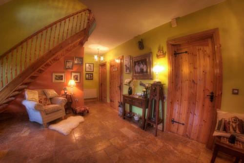 a living room with a staircase and a chair at Walkers Nest in Carlingford