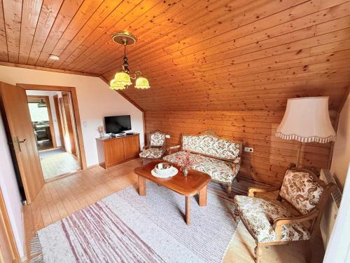 ein Wohnzimmer mit Sofa und Tisch in der Unterkunft Sonnenplatz Appartment Ploninger LANDHAUS in Bad Kleinkirchheim