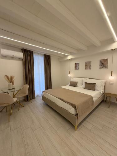 a bedroom with a large bed and a table at Seraphia Apartment in Palermo