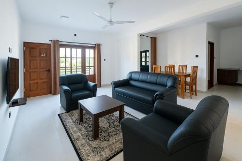 GangodawilaにあるACCOM Premium Residenceのソファと椅子とテーブルのあるリビングルーム