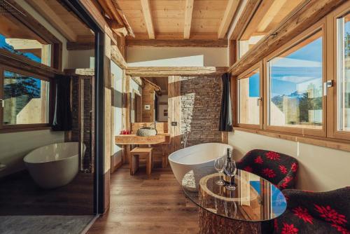 un bagno con una vasca, un tavolo, una vasca da bagno e un lavandino di Hotel Ciasa Lorenzi a Cortina dʼAmpezzo