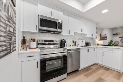 a kitchen with white cabinets and a stainless steel oven at Dont Overpay-2Bd 1 Bath -Calm Family Place in Calgary