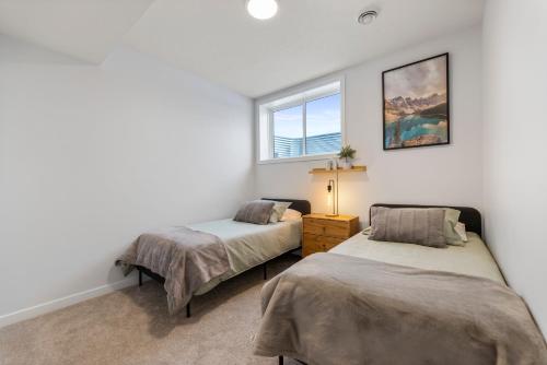 a bedroom with two beds and a window at Cozy 2-Bed 1 Bath Entire Place in Calgary