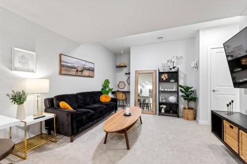 a living room with a black couch and a table at Dont Overpay-2Bd 1 Bath -Calm Family Place in Calgary