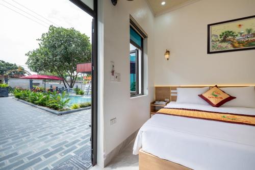 a bedroom with a bed and a view of a courtyard at Tam Coc Anna Villa in Ninh Binh