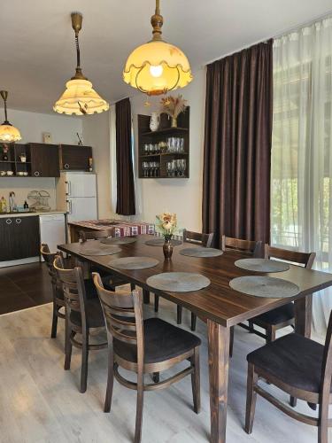 a kitchen and dining room with a wooden table and chairs at Бадевски рай- къща София in Veliko Tŭrnovo
