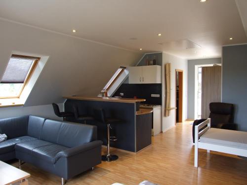 a living room with a couch and a kitchen at Ferienwohnung am Betschkamp in Schneverdingen