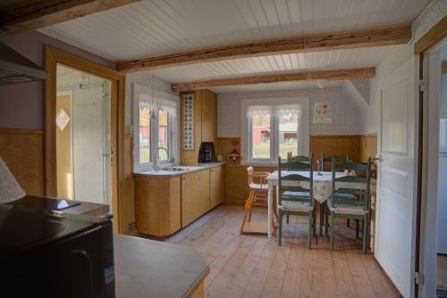 a kitchen and dining room with a table and chairs at Sommargyllen Torp Brändabo in Torsås