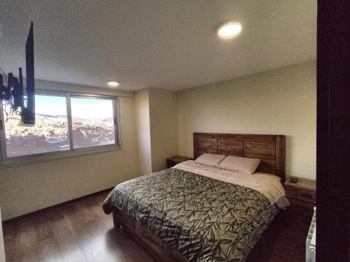 ein Schlafzimmer mit einem großen Bett und einem Fenster in der Unterkunft The Poet's Apartment in La Paz