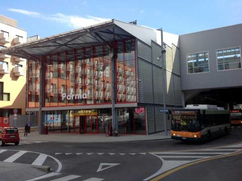 a bus is parked in front of a building at Europe Station House in Parma
