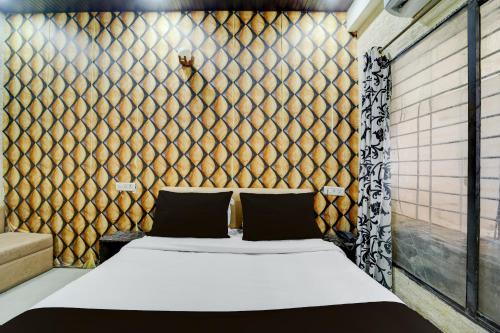 a bedroom with a bed in a room with a wall at HOTEL O THE 9 CUBE in Habībganj