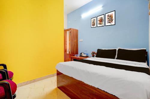 1 dormitorio con cama blanca y paredes amarillas en Hotel O R R Comforts Boarding and Lodging, en Nelamangala