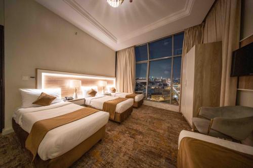 a hotel room with two beds and a window at Afaq Taiba Hotel in Medina