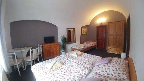 a bedroom with two beds and a table and chairs at Mini Apart Hotel Abraka in Český Krumlov
