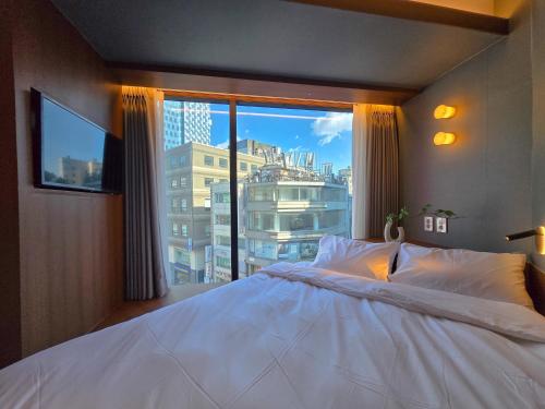 a bedroom with a large white bed and a large window at 스테이 마루 종로 Stay Maru Jongno in Seoul