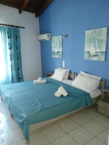 a blue bedroom with a bed with towels on it at Smaragdi in Chania