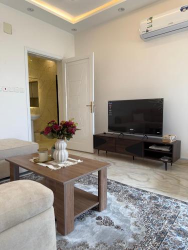 a living room with a television and a coffee table at Apartment in Tabuk