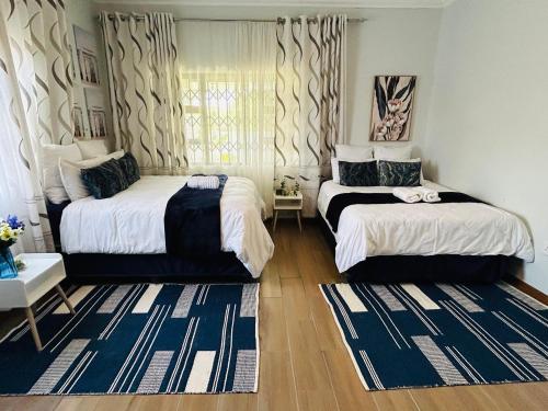 a bedroom with two beds and a window at Hope Villa Luxury Accomodation in Odendaalsrus