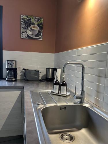 a kitchen sink with two bottles of wine on it at GITE DE 6 A 14 PERSONNES Chez Léontine in Lacave