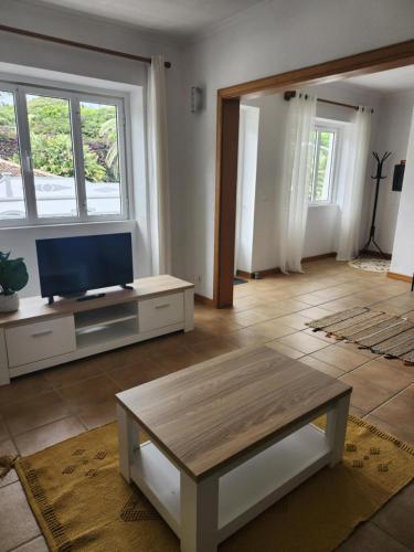 a living room with a tv and a coffee table at Casa dos Amigos in Angra do Heroísmo