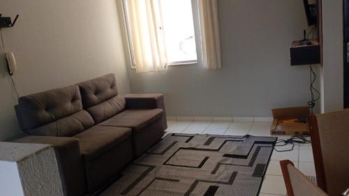 een woonkamer met een bank en een raam bij Apartamento no centro de Ananindeua in Ananindeua