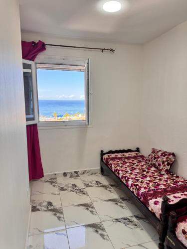 a bedroom with a bed and a window at Filfila skikda in Rebaïb
