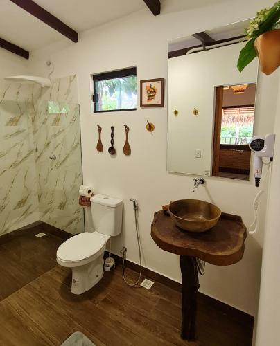 a bathroom with a toilet and a wooden sink at Casa Saimiri in Alter do Chao