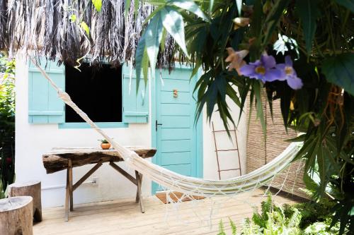 カライーバにあるPousada do Rio Caraívaの青い扉付きの家の前のハンモック