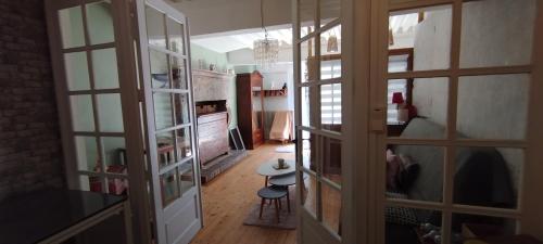 a hallway with glass doors and a table in a room at Jura entre Lacs et Montagnes Charmant studio cosy de 38 m2 in Orgelet