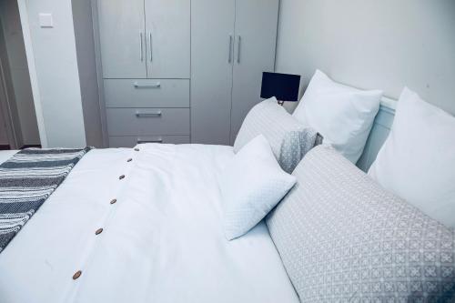 a bedroom with a white bed with pillows at Apartment One bedroom Nairobi in Nairobi