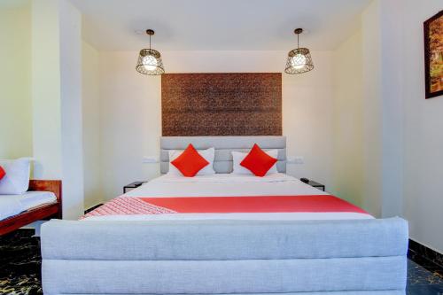 a bedroom with a large bed with red pillows at Hotel O P S Grand in Port Blair