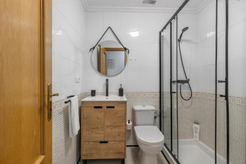 Un baño con inodoro, lavabo y espejo. en Homely Apartments Las Salinas, en Torrevieja