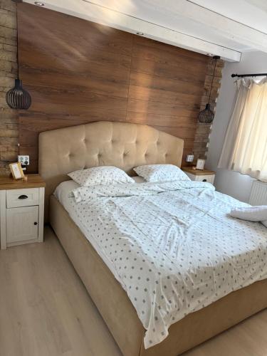 een slaapkamer met een groot bed met een houten wand bij Apartament Str Crinului Cluj in Cluj-Napoca
