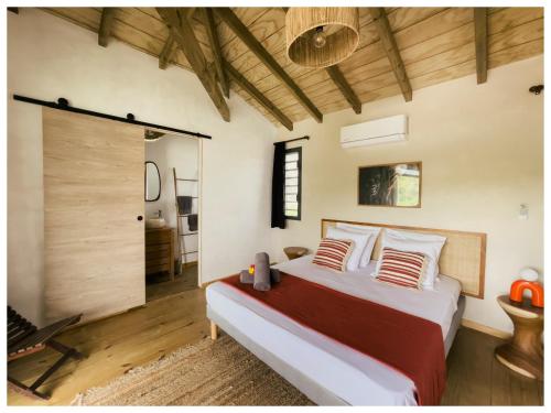 a bedroom with a large bed and a sliding glass door at Les pilotis in Courcelles Sucrerie