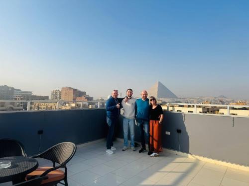 Un gruppo di persone che si trovano su un tetto di Phoenix Pyramids View Inn a Il Cairo