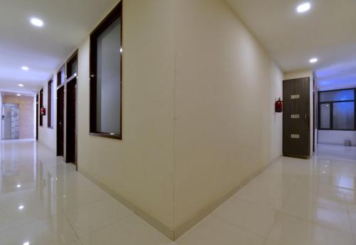 Hotel O Heritage Haveli في جايبور: ممر بجدران بيضاء وباب زجاجي كبير