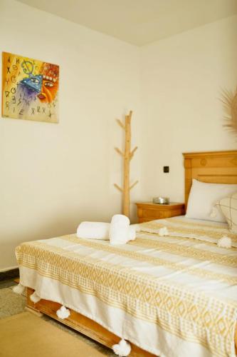 sypialnia z dwoma łóżkami i obrazem na ścianie w obiekcie Nest Surf Housse Anza w mieście Agadir