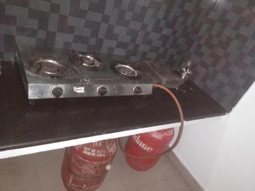 a stove with two soda cans under a counter at WooLiv in Coimbatore