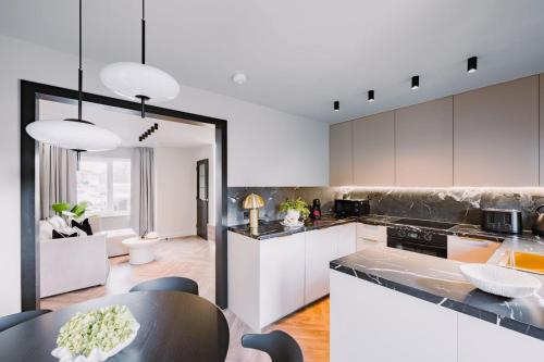 a kitchen with white cabinets and a black table at JW Executive ApartHouse 2 in Glasgow
