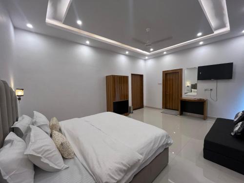 a bedroom with a bed and a flat screen tv at Hotel Dream Inn Khajuraho in Khajurāho