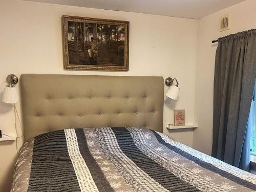 OrmarydにあるCharming Cottage by Sjunnaryd Lakeの壁に絵が飾られたベッドのある寝室