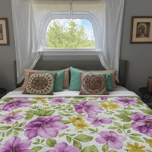a bed with a floral bedspread and a window at MODERN LUX 3BR HOME - King Bed - 10 mins to FT HOOD - Fenced yard - Pets ok- Family friendly -LONG or SHORT TERM in Copperas Cove