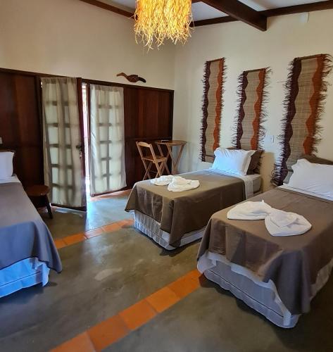 a room with two beds and a chandelier at Casa Saimiri in Alter do Chao