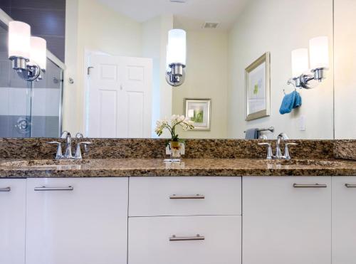 a bathroom with two sinks and a large mirror at Stylish 3-BR with Private Pool & Conservation View in Orlando