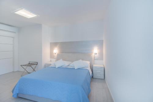 a bedroom with a bed with a blue bedspread at SWEETHOME TALVERA - con Garage in Bolzano