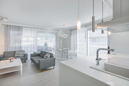 a kitchen and living room with a sink and a couch at SWEETHOME TALVERA - con Garage in Bolzano