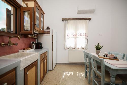 a kitchen with a refrigerator and a table with chairs at Imellos in Apeiranthos