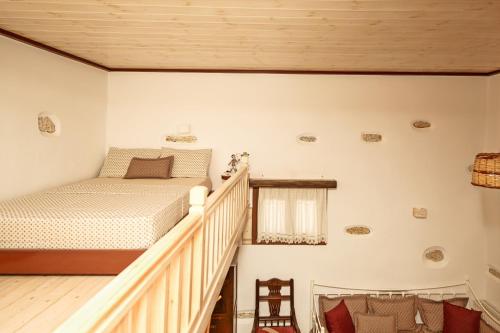 a bedroom with a bed and a staircase at Imellos in Apeiranthos