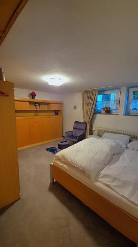 ein Schlafzimmer mit einem großen Bett und einem Stuhl in der Unterkunft Einzelzimmer in Oberhausen Alstaden für 3 Personen ohne Küche, Gefrierschrank und Mikrowelle Vorhanden!! in Oberhausen