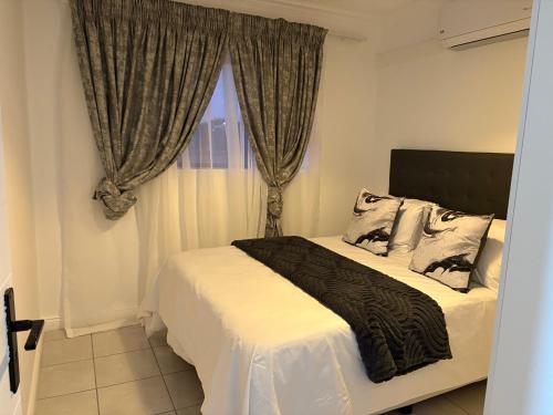 ソウェトにあるFUSH guesthouseのベッドとカーテンのついた窓のある寝室